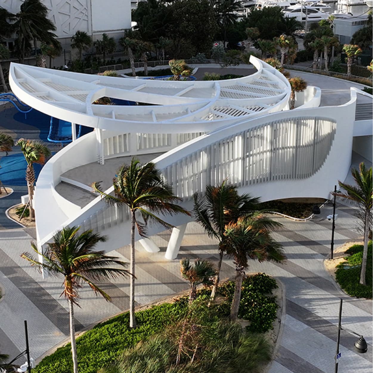 Pedestrian park with geometric patterned screens casting dramatic light and shadow in Fort Lauderdale